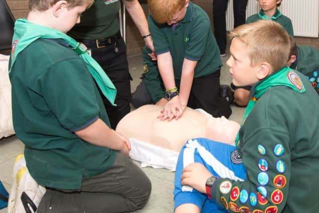 A responder from LIVES helps scouts learn all about first aid
