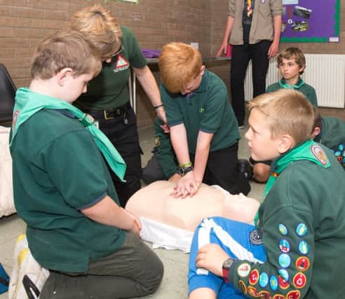 A responder from LIVES  helps scouts learn all about first aid