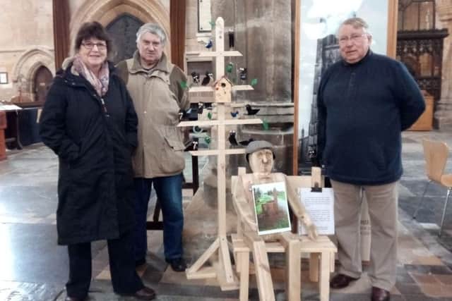 Jane Kay, Dereck Harvey and Colin Griggs with the wooden tree and new wooden man in The Stump. EMN-170303-110052001