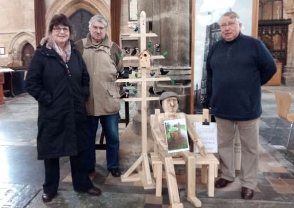 Jane Kay, Dereck Harvey and Colin Griggs with the wooden tree and new wooden man in The Stump. EMN-170303-110052001