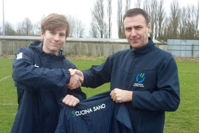 Saints skipper Matthew Dickens is pictured receiving the clubs new rain jackets.