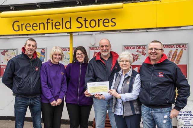 Margaret Conyers is pictured handing over the cheque to RNLI crew members Carl Holmes, Tom Freeman and Shaun Riggall. Also pictured are shop staff members Christine Johns and Michelle Shepherd.