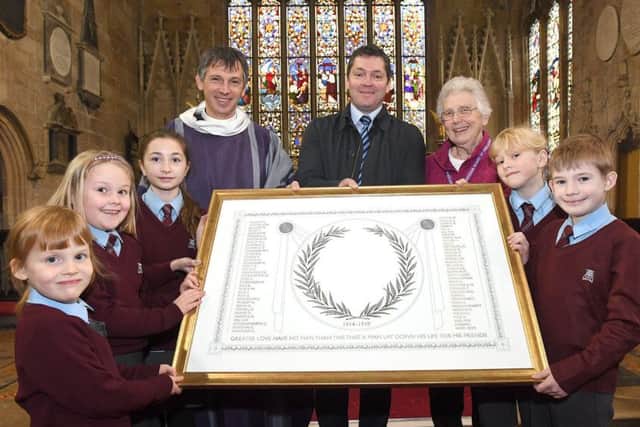 William Alvey school pupils presenting a scroll of the pupils that died in the First World War, to St Deny's Church. From left - Hazel Moran 5, Sophie Parsbo 7, Erin Clifford 11, Rev Philip Johnson, Stephen Tapley - head teacher, Beryl Risdell - bishop's visitor for Alvey School, Paige Hobbs 9 and Jacob Pope 8. EMN-170316-152336001
