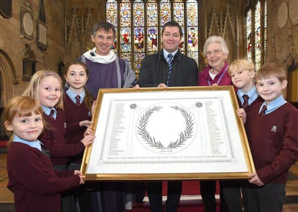 William Alvey school pupils presenting a scroll of the pupils that died in the First World War, to St Deny's Church. From left - Hazel Moran 5, Sophie Parsbo 7, Erin Clifford 11, Rev Philip Johnson, Stephen Tapley - head teacher, Beryl Risdell - bishop's visitor for Alvey School, Paige Hobbs 9 and Jacob Pope 8. EMN-170316-152336001