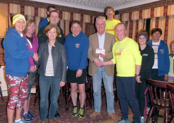 Katy Hewis, left, with Julia Whittaker (Caistor Cares), Luke Kireia (LIVES) and Chris Hewis and Lion President Peter Morris with Chairman of the Running Club Andy Bell. (Photo by Linda Oxley) EMN-170329-092040001
