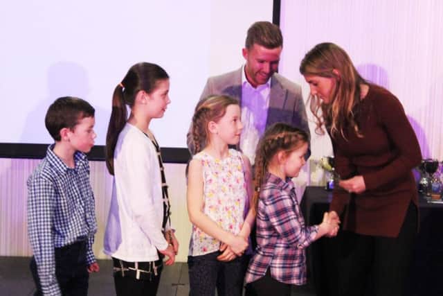 The eight and under team collect their trophy from Dan Cox and Jade Windley.
