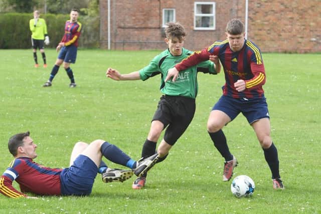 Fulbecks Frasier Harding attempts to squeeze beyond Railways Scott Wiseman and Liam Nimmo.