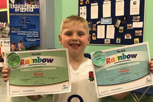 =Swim star Henry Seagroatt pictured with his latest swim badges.