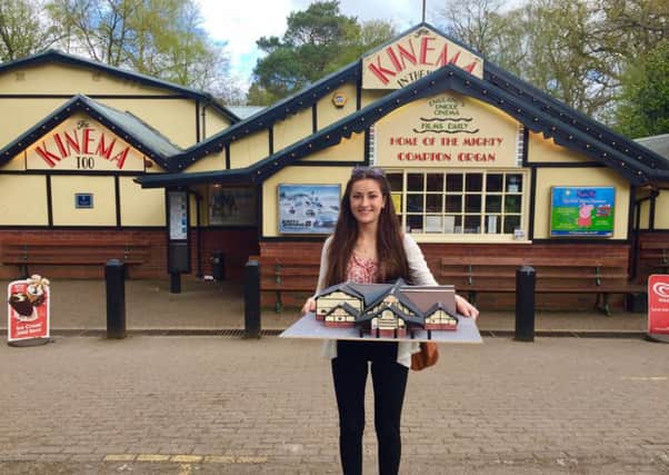 Holly Parkinson is pictured holding her Kinema In The Woods architectural model, in front of the venue itself. EMN-170417-154720001