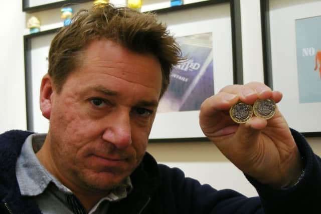 Fake or misprint? Nathan Everest with the the suspect £1 coin and a genuine one. EMN-170405-122438001