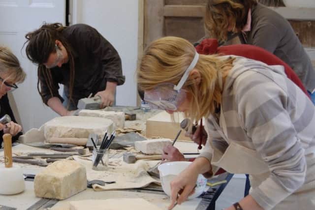 Visitors taking part in a stone carving workshop. EMN-170517-142028001