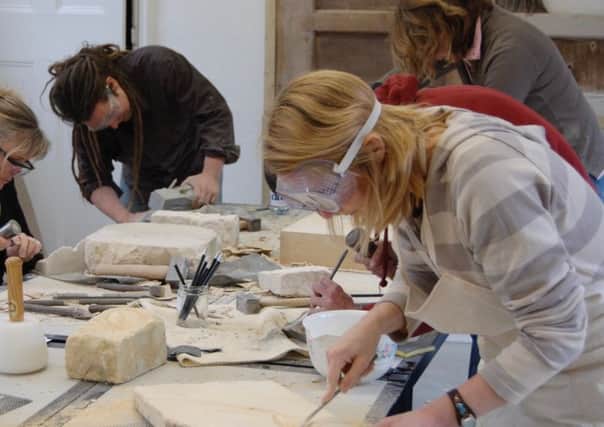 Visitors taking part in a stone carving workshop. EMN-170517-142028001