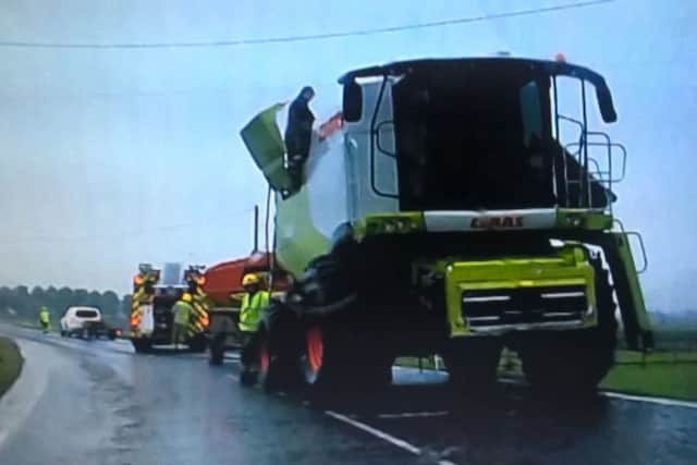 Firefighters direct traffic as they damp down the burnt out combine harvester at Anwick Fen. Photo Liz Waters EMN-170519-103042001