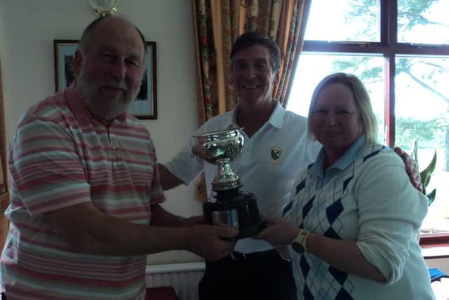 Market Rasen men's captain Gaff Elliott (centre) presents the Phillips Family Foursome Cup to Michael and Sue Archer EMN-170522-145410002