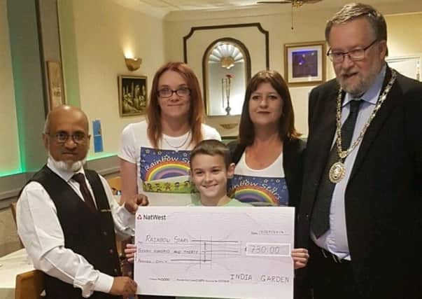 Nadim Aziz of the India Garden presenting the cheque with Mayor David Suiter to Hannah Owen and Jane Peck (and Ellis) of Raonbow Stars from their banquet nights. EMN-170523-172341001
