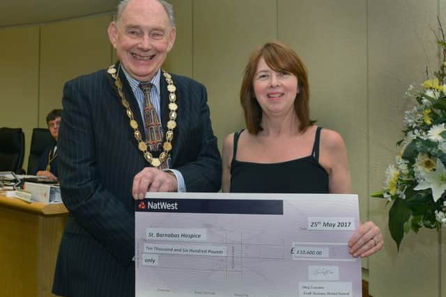Outgoing council chairman John Money hands over £10,600 to St Barnabas fundraising co-ordinator Tina Quigley. Photo: Mick Fox (supplied)