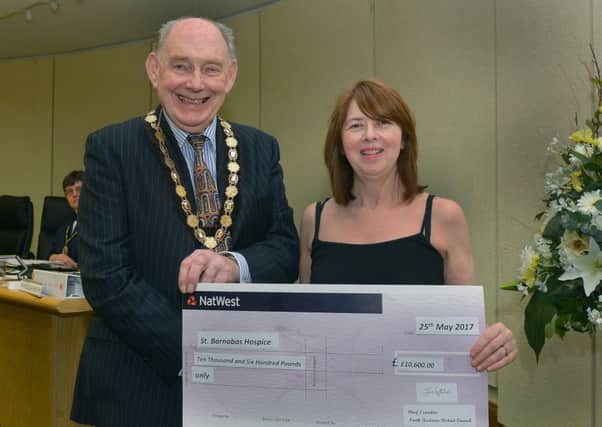 Outgoing council chairman John Money hands over Â£10,600 to St Barnabas fundraising co-ordinator Tina Quigley. Photo: Mick Fox (supplied)