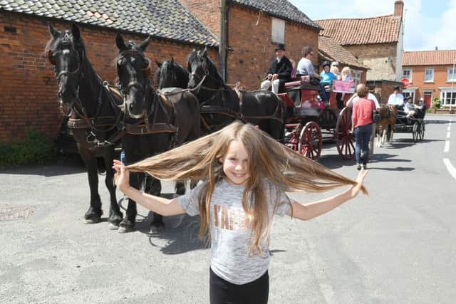 Rosie-Mai pictured before the hair cut, in front of the horses and carriages. EMN-170613-102025001