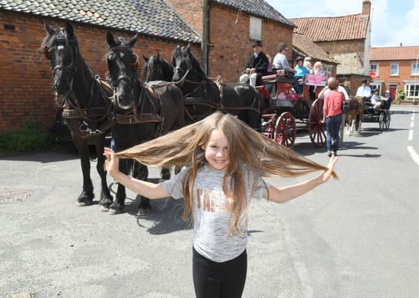 Rosie-Mai pictured before the hair cut, in front of the horses and carriages. EMN-170613-102025001