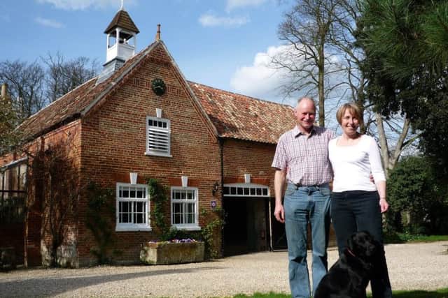 Paul and Flora Bennett with their Labrador, Jessie, in front of Brackenborough Hall Coach House.
