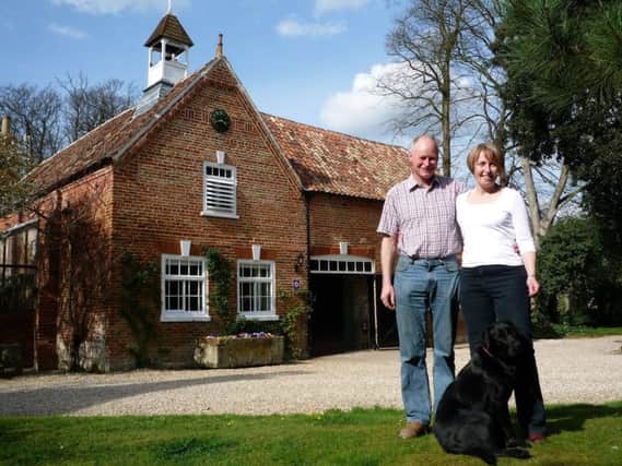 Paul and Flora Bennett with their Labrador, Jessie, in front of Brackenborough Hall Coach House.