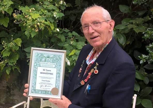 Fred Parker with the framed certification to mark his 60 years in beekeeping. EMN-170616-112910001