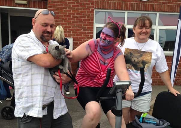 Richard Henry, who has adopted a dog from HART, is holding Benny the cat, with Joanna cycling and Tracy Healy. EMN-170626-171017001