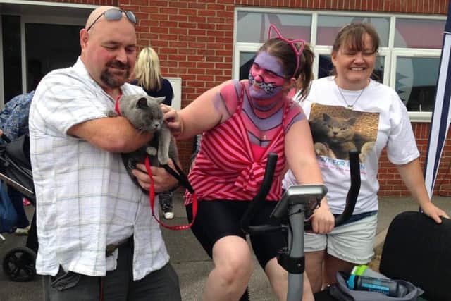 Richard Henry, who has adopted a dog from HART, is holding Benny the cat, with Joanna cycling and Tracy Healy. EMN-170626-171017001