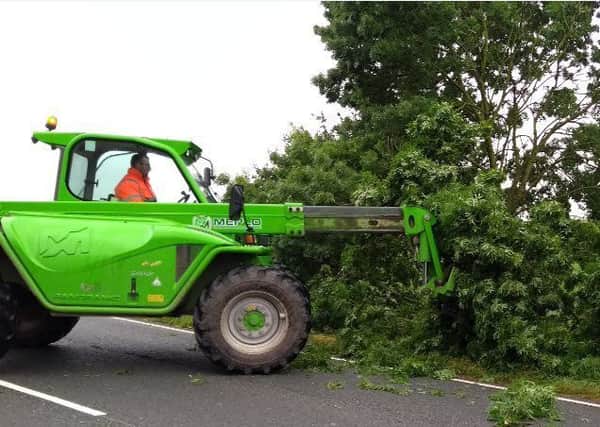 Farmers help police clear a fallen tree today (Wednesday) on the A52 at Bridge End, near Horbling. EMN-170628-174850001