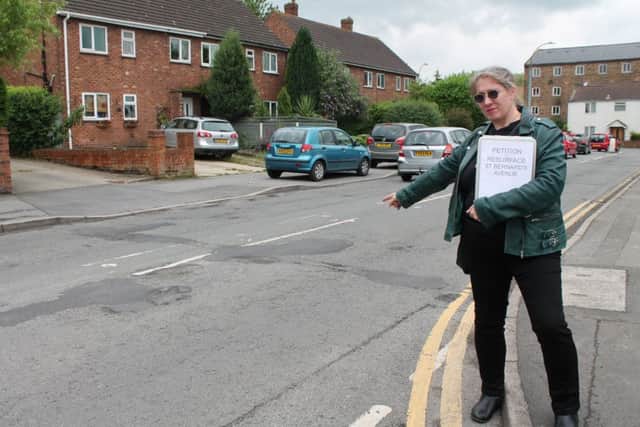 Councillor Ros Jackson with some of the potholes in St Bernard's Avenue.