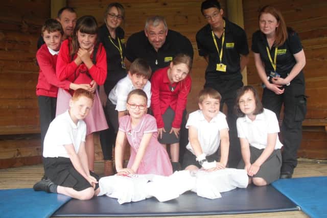 Pupils practicing their CPR technique on model dummies, joined by LIVES representatives. EMN-170707-145946001