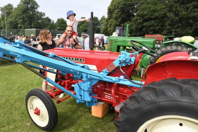 Alison and Simon Saxby with Oscar Saxby, 3, looking at tractors.at Spilsby Show. Photo: MSKP-090717-3 ANL-171007-122725001