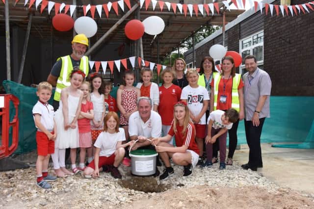 Pupils from Wragby Primary School pictured assisting Alan Long Lincoln City Football Club Community Officer to bury a Time Capsule in the ground adjacent to the new class room that is presently under construction. Photo by John Edwards EMN-171007-082234001