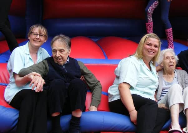 Ashdene care home staff Judith Mableson and Laura Cook on the bouncy castle at the fun day with residents Clive Wood and Gladys Hatcher. EMN-170108-113216001