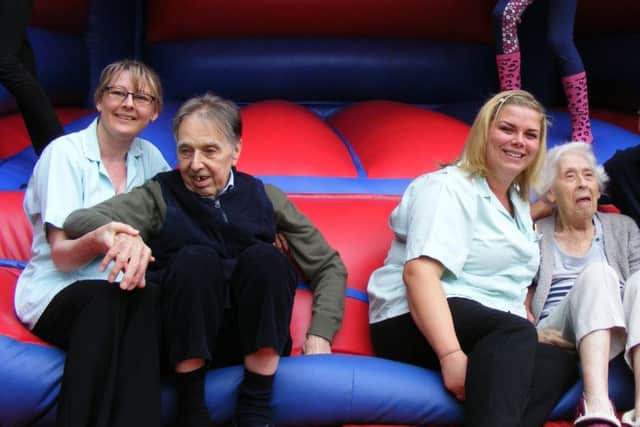 Ashdene care home staff Judith Mableson and Laura Cook on the bouncy castle at the fun day with residents Clive Wood and Gladys Hatcher. EMN-170108-113216001