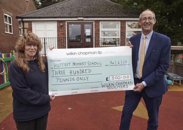 Huttoft Primary School headteacher, Alison Hurrell receives the cheque from Rupert Houltby, a partner from Wilkin Chapman, which has an office in Alford. Photo: Alison Mitchell ANL-170727-063212001