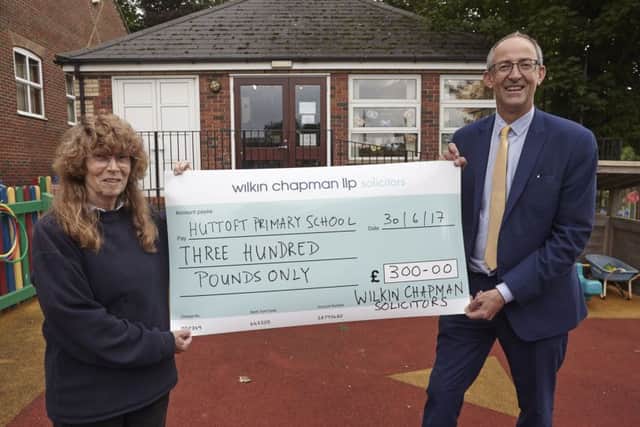 Huttoft Primary School headteacher, Alison Hurrell receives the cheque from Rupert Houltby, a partner from Wilkin Chapman, which has an office in Alford. Photo: Alison Mitchell ANL-170727-063212001