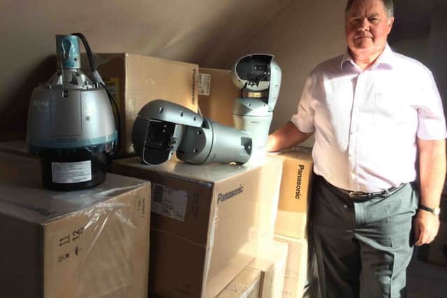 Coun Marsh with some of the digital cameras which, 13 months on, are still in their boxes. EMN-170708-141850001
