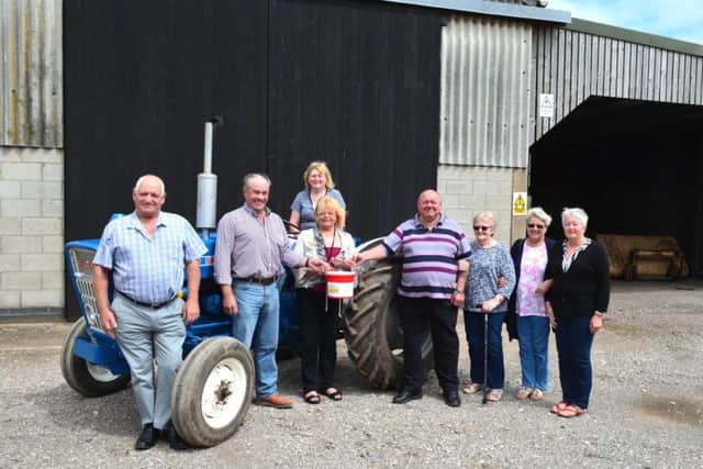 Tractor Run organisers Leslie Lomas (left), Richard Thompson (second left) and Stuart Lindley (fourth from right) hand over their fundraising donation to Anne Millett of Lindsey Lodge Hospice (third from left). They are pictured with (from left to right) Jean Thompson (seated), Sheila Lindley, Denise Knowles and Jenny Lomas. EMN-170908-084203001