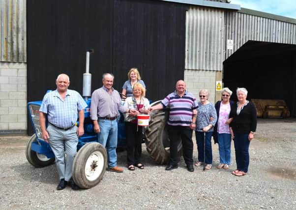 Tractor Run organisers Leslie Lomas (left), Richard Thompson (second left) and Stuart Lindley (fourth from right) hand over their fundraising donation to Anne Millett of Lindsey Lodge Hospice (third from left). They are pictured with (from left to right) Jean Thompson (seated), Sheila Lindley, Denise Knowles and Jenny Lomas. EMN-170908-084203001