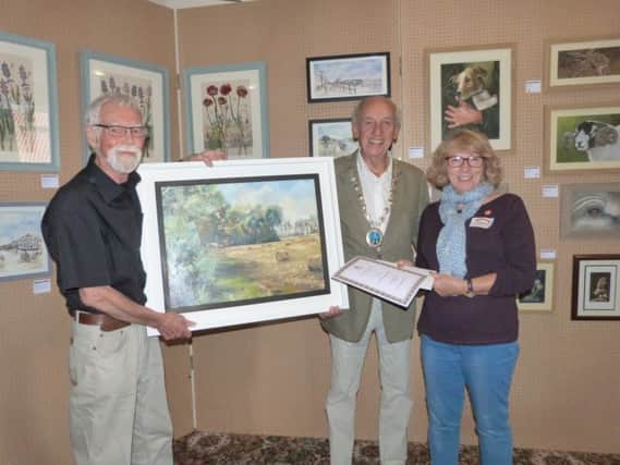 Louth artist Pat Rowe was the winner of the best picture in the exhibition, with judge Noel Black, left, and Mayor of Caistor Alan Somerscales. EMN-170509-164711001