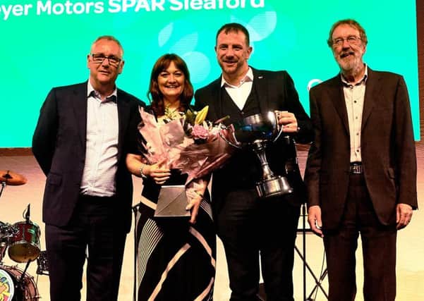 Rachael Hockmeyer and Christian Slingsby (centre) of Hockmeyer Motors receive their Baldwin Trophy award at the Spar Retail Show. EMN-170913-110929001