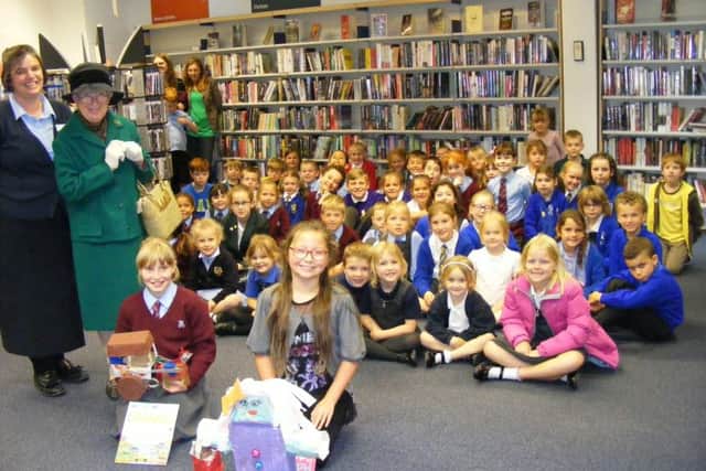 Library customer service adviser Clare Gibson and 'Miss Marple' with children who have earned their summer reading challenge certificates. EMN-170918-142323001