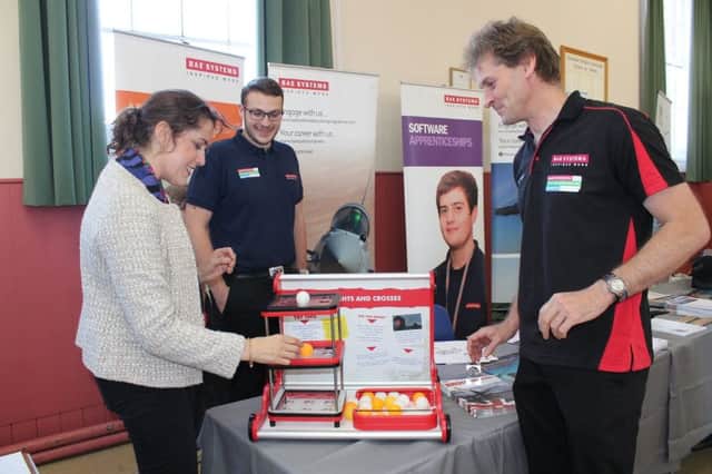 Victoria Atkins MP tries her hand at '3D Connect Four' with Michael Lewis, a software engineer from BAE Systems.