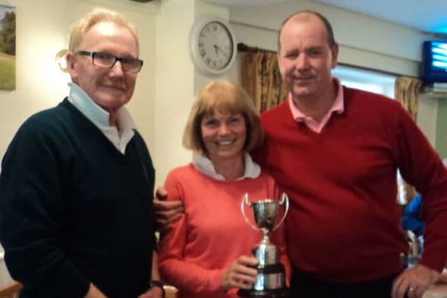 Past captain Graham Dolan (left) presents the Ainsworth Trophy to winners Dave and Hilary Tuhey EMN-170925-120808002