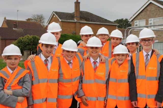 Pupils donned personal protection equipment while waiting to go on the building site. EMN-170210-140057001
