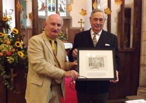 John Bangay presents the commemorative Gertrude Reed drawing to churchwarden Trevor Bush during Sundays harvest festival service inthe church. EMN-171010-115434001