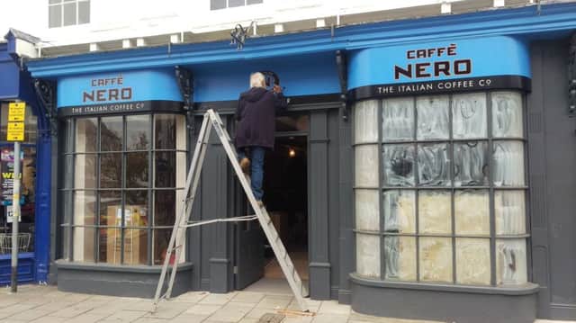 A decorator adds a few 'finishing touches' to the new CaffÃ¨ Nero in Louth.